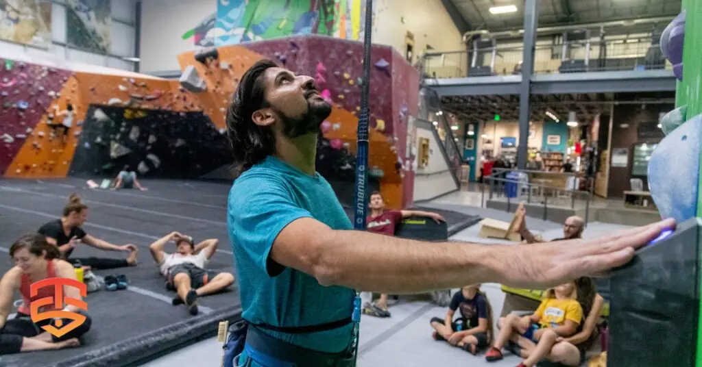 TRUBLUE iQ auto belay mounted on a commercial climbing gym wall